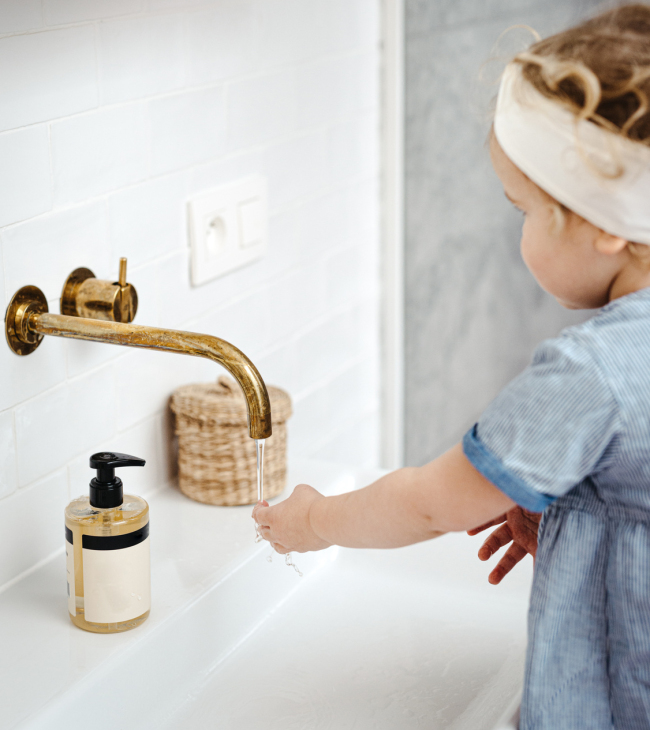 Kind wast handen onder een kraan